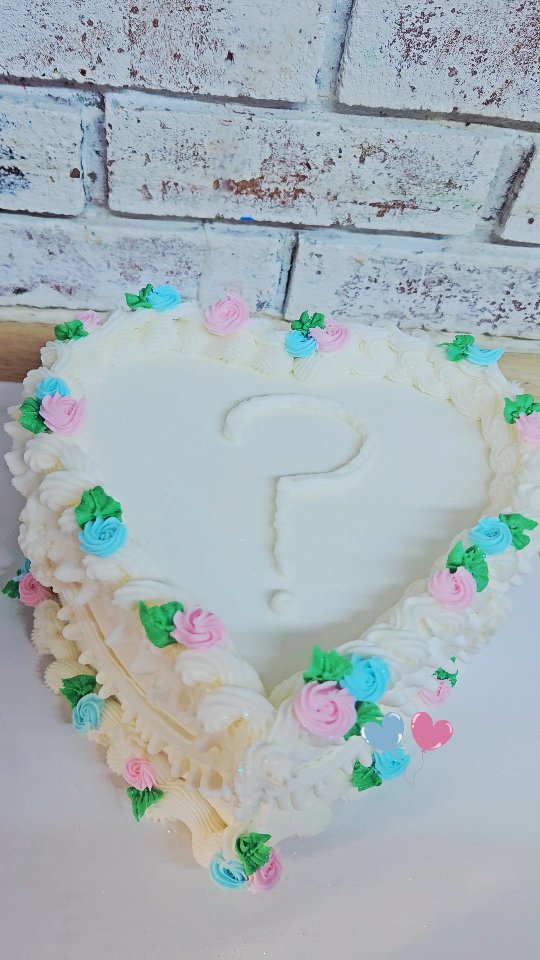 White heart-shaped cake with a floral wreath design